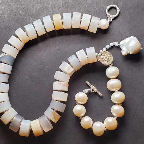 Necklace of agate, fine silver, and freshwater pearls, hand-knotted between each bead. A large baroque pearl dangles from from one side.