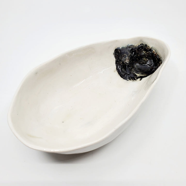 Multi-fired porcelain dish depicting a resting black bear. 