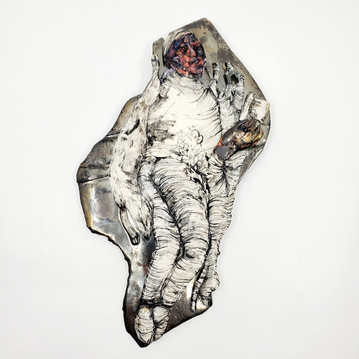 Figure Hunting : multi-fired porcelain wall sculpture of a figure hunting.