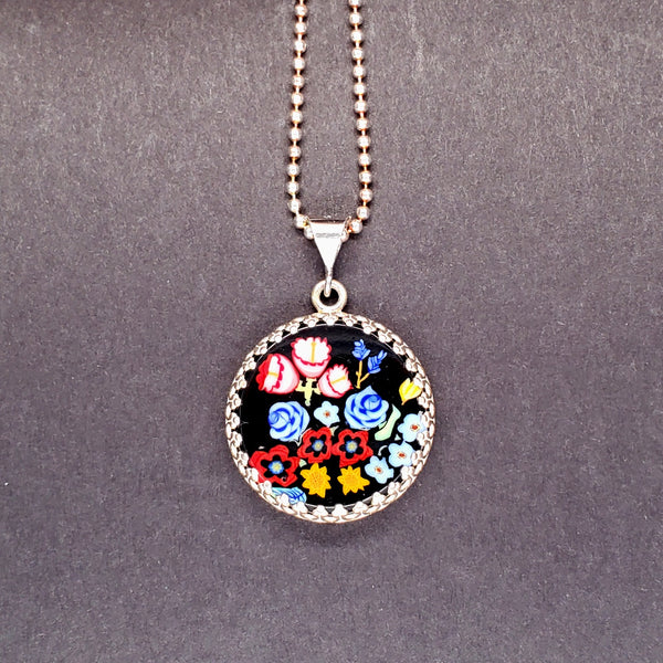 Botanical murrine glass pendant on a sterling silver chain.