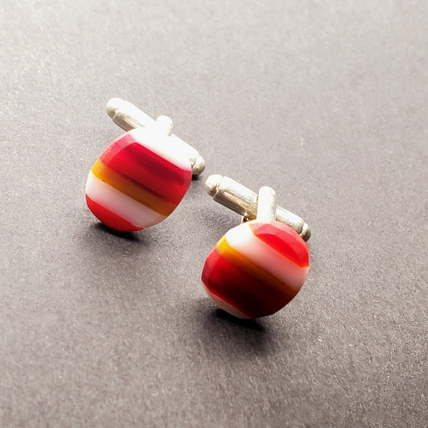 Striped red cufflinks of flame-worked glass.