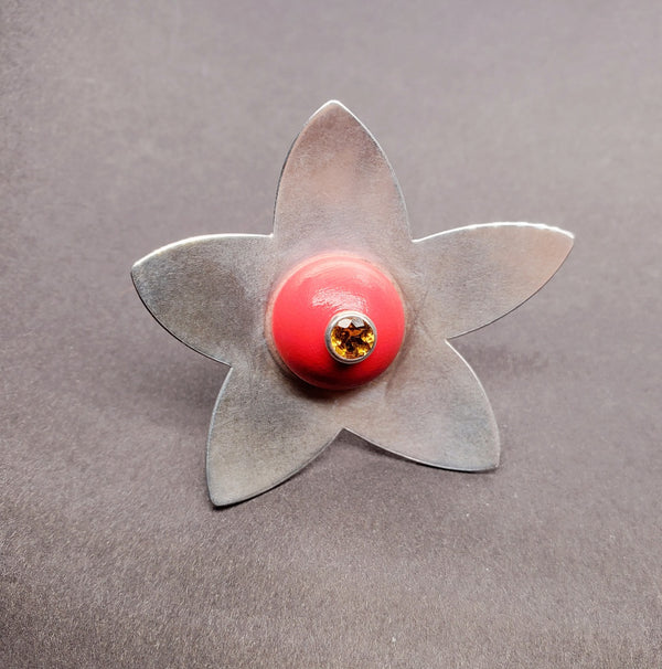 A large red wood bead topped with a citrine rests amid 5 large petals of sterling silver, 5 x 2 cm.