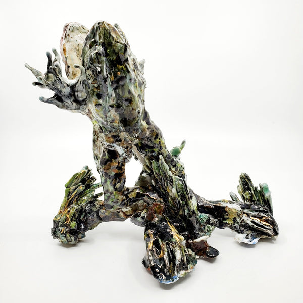 Porcelain sculpture of two frogs in an embrace, leaping together from the water. Pond growth reaches up around their feet. Richly textured with both colour and line, these spotted green frogs are streaked with gold lustre. 