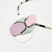 Pastel Geo Sewn Necklaces combine repurposed powder-coated copper and fibre art. The metal segments are stitched together with embroidery thread, which also winds around the cotton cord.