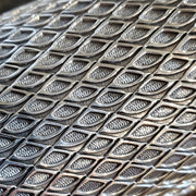 Sterling silver cuff, stamped with a geometric pattern. Within the pattern, there is a subtle texture in the oxidized spaces between the bright silver lines.