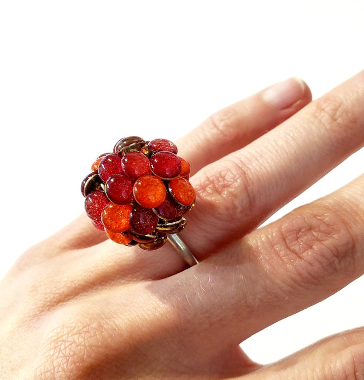 Round Red Resin Ring. Droplets of red resin and sterling silver are sewn in with golden yellow thread. This 2.2cm x 2.2cm centerpiece sits on a size 6.5 sterling silver shank.