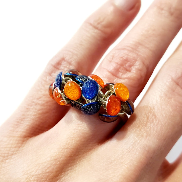 Blue and Orange Resin Ring. Droplets of blue and orange resin and sterling silver are woven together with sterling silver jump rings. On a size 6.5 sterling silver shank.