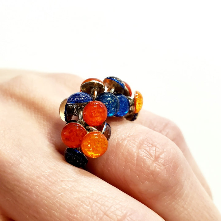 Blue and Orange Resin Ring. Droplets of blue and orange resin and sterling silver are woven together with sterling silver jump rings. On a size 6.5 sterling silver shank.