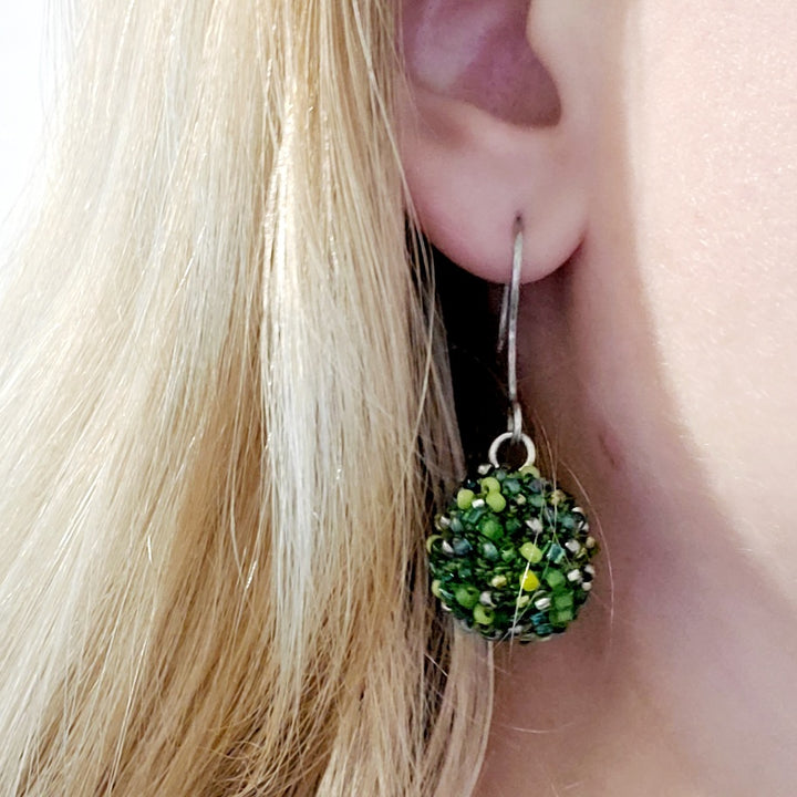 Short Green Earrings. Green glass beads are sewn in with green thread. These earrings hang 4.5cm long, and are on sterling silver hooks.