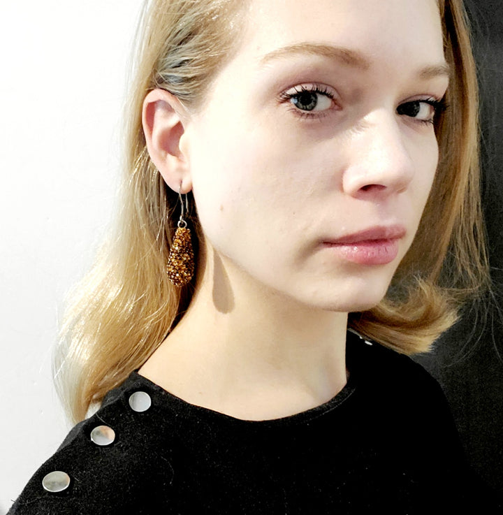 Golden Drop Earrings. Brown and clear glass beads are sewn in with golden yellow thread. These earrings hang 6cm long, and are on sterling silver hooks.