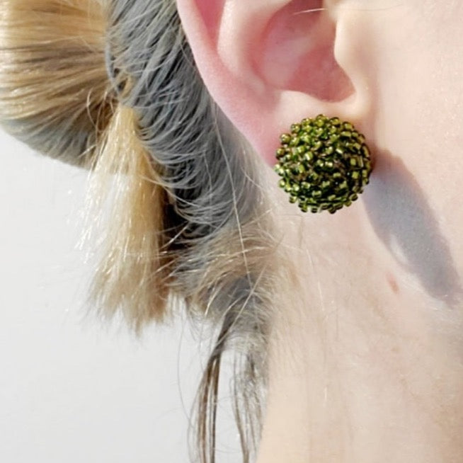 Green and Silver Clip-On Earrings. Green glass beads are sewn in with silver grey thread. These earrings measure 1.8cm in diameter, and have sterling silver clips.