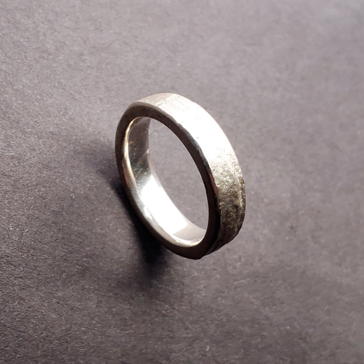 Origins narrow band sterling silver ring. The surface texture is from an impression of slate. Size 8.75