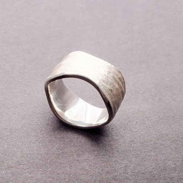 Origins wide band sterling silver ring. The texture is an impression of slate. Size 7.5