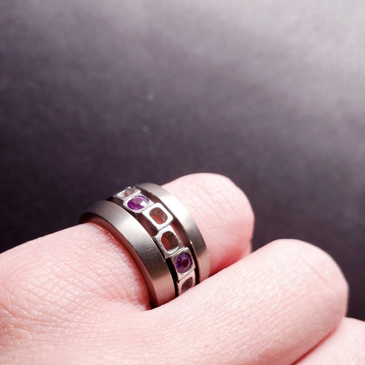 Geometrica stacking ring set with 5 purple sapphires interspaced across the staggered cubes of the sterling silver band, best worn between the 2 titanium bands.