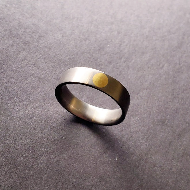 Gold Dot (24k) set into a comfort fit titanium band that is 6 mm wide and fits a size 10.