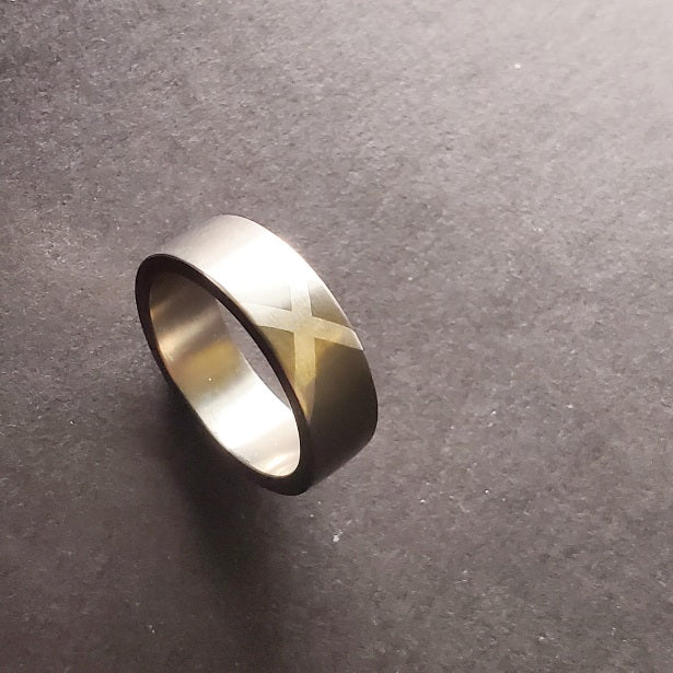 A sweeping fine silver "X" marks the spot, impeccably inlaid on the 7 mm titanium band. Size 9.