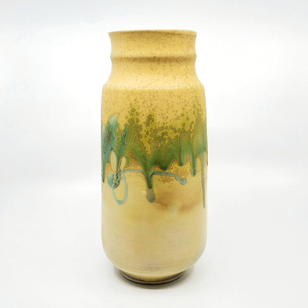 Yellow vase. Round thrown vase with a textured green surface decoration wrapping around the center of the form.