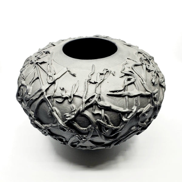 Large black vase. Ribbons of clay applied to its surface create a strong texture.