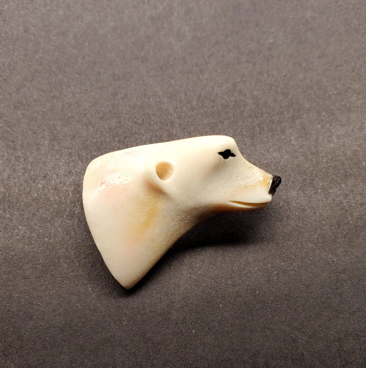 Bear head pin made from caribou antler.