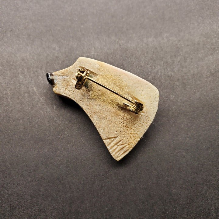 Bear head pin made from caribou antler.
