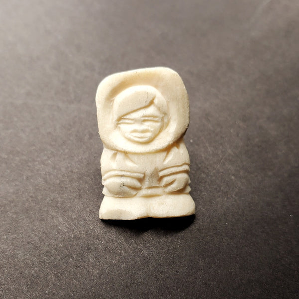 Small figure pins made from polar bear bone, with locking pin backs.