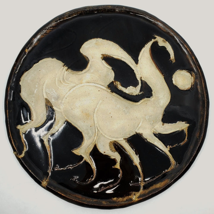 Ceramic plate depicting two horses. 12" in diameter.