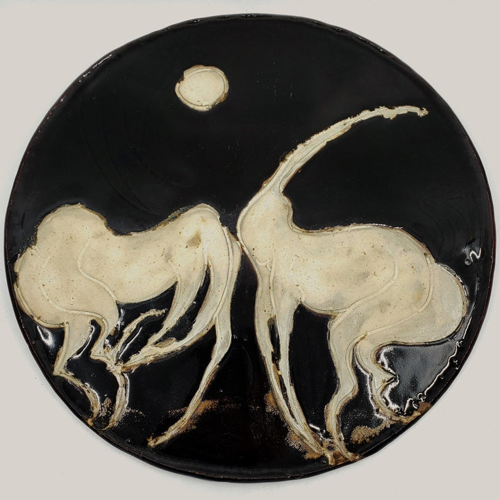 Ceramic plate depicting two horses. 12" in diameter.