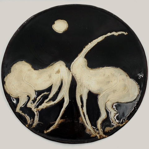 Ceramic plate depicting two horses. 12" in diameter.