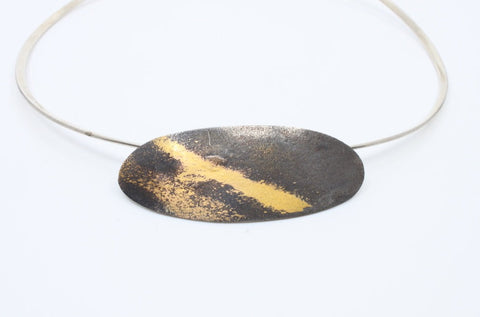 Aggie Beynon Pendant is composed of silver, pure gold and copper. The oval pendant is situated on a sterling silver collar.