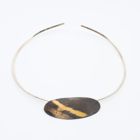 Aggie Beynon Pendant is composed of silver, pure gold and copper. The oval pendant is situated on a sterling silver collar. 
