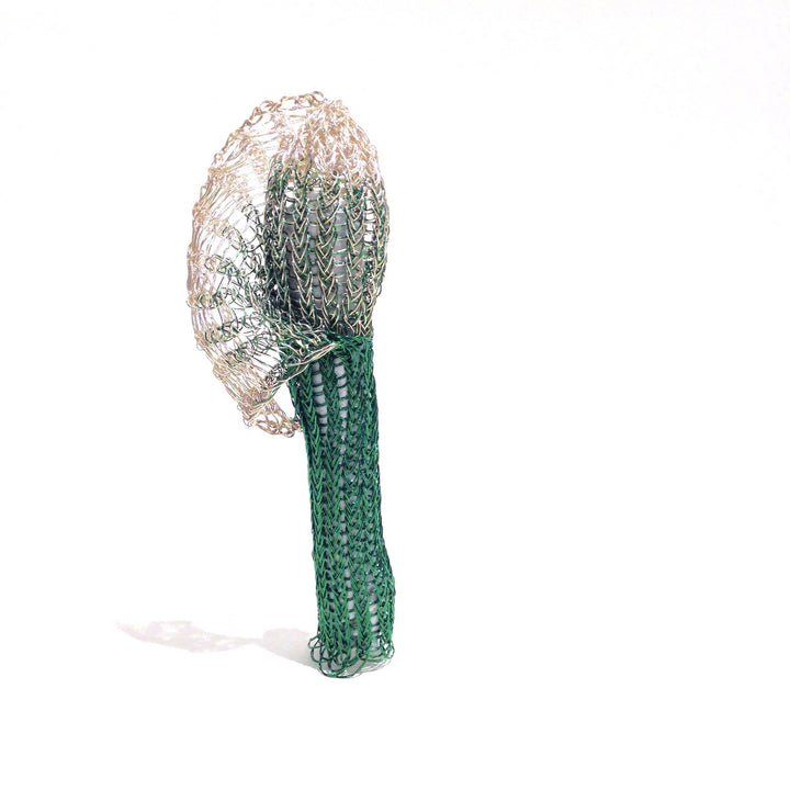 Green and silver On Being Female brooch with coloured copper wire, copper, brass, spandex and tampons.