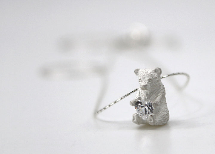 Heart Hugger. Bear pendant necklace of sterling silver, with a heart-shaped Swarovski cubic zirconia crystal.  Full of pure love, this bear is putting his little heart out. This is a one of a kind design.
