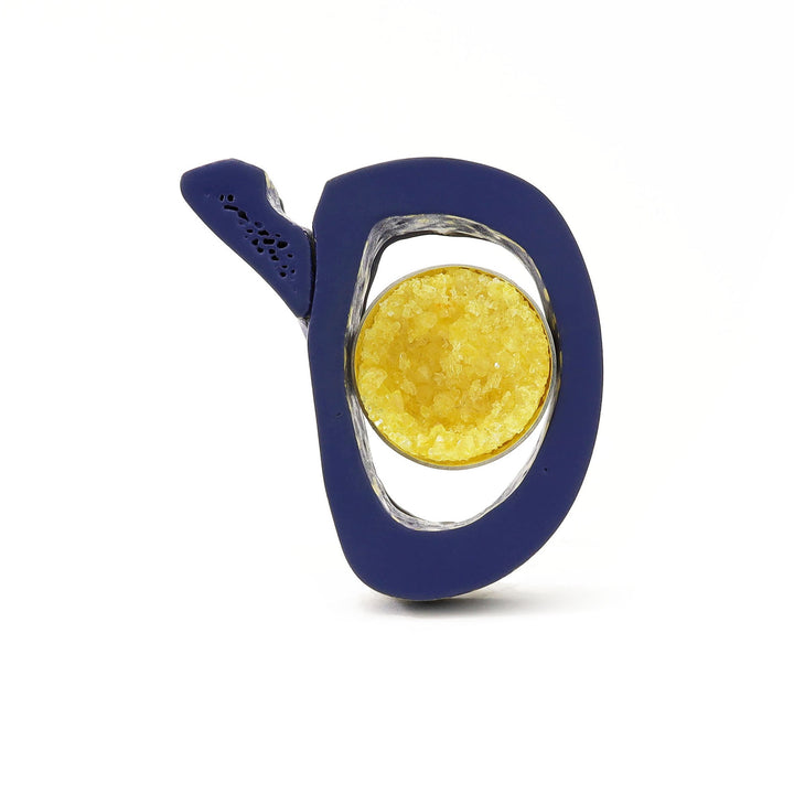 What Remains - Brooch of lacquered dark blue bovine bone with yellow crystal, sterling silver, and nickel silver.