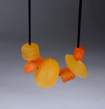 Asymmetric Beaded Necklace. Necklace of blown glass and solid glass beads in orange, on an adjustable length suede leather cord.
