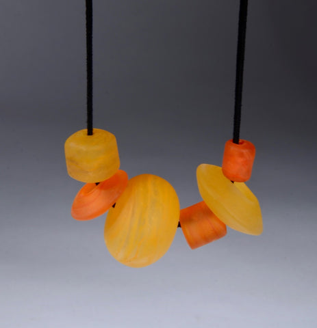 Asymmetric Beaded Necklace. Necklace of blown glass and solid glass beads in orange, on an adjustable length suede leather cord.