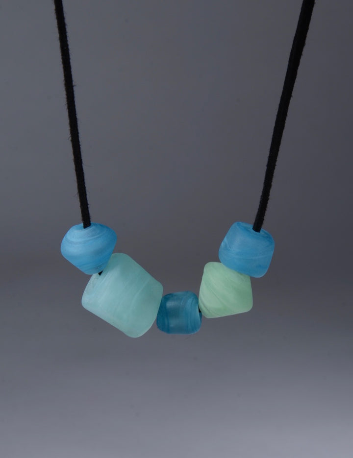 Asymmetric Beaded Necklace. Necklace of blown glass and solid glass beads in aqua, on an adjustable length suede leather cord.