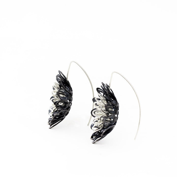Dahlia, large and breathtakingly light drop earrings of sterling silver and silver with an oxide patina. The petals radiate with lively energy from the play of the negative space with the two colours.  3.5 x 1 cm 