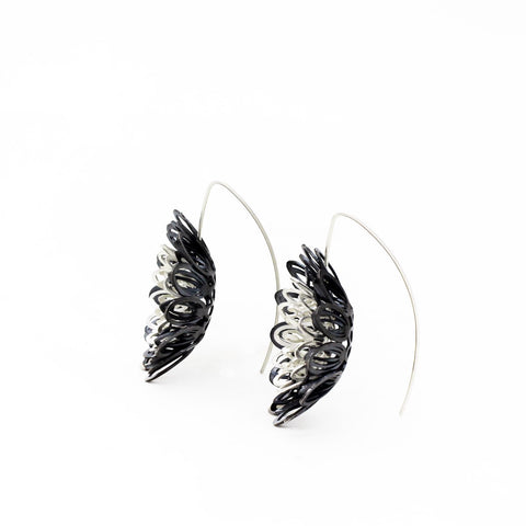 Dahlia, large and breathtakingly light drop earrings of sterling silver and silver with an oxide patina. The petals radiate with lively energy from the play of the negative space with the two colours.  3.5 x 1 cm 