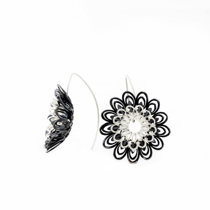 Dahlia, large and breathtakingly light drop earrings of sterling silver and silver with an oxide patina. The petals radiate with lively energy from the play of the negative space with the two colours.  3.5 x 1 cm 