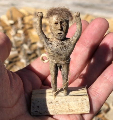 Small man with hair holding his arms up statue