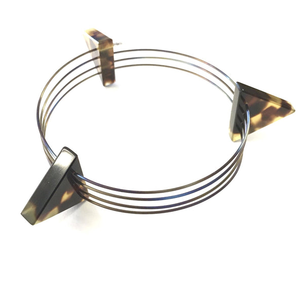 Triangle bangle in Titanium with cellulose acetate tortoise shell like triangles. Bangle interior width of 7.5 cm and maximum total width of 10.5 cm.