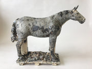 Small Gray Horse 2. Ceramic sculpture of a horse. Its beautiful dappled texture was achieved with layers of coloured engobes and glazes. This sturdy steed measures 40 x 10 x 30 cm.