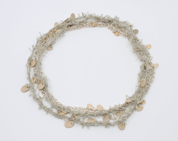 A long beige linen thread neckpiece with birch plywood tabs mirrors its sterling silver rope twist chain with silver and 10k yellow gold tabs. A sensuous material play, they can be worn singly. 42"/106 cm.