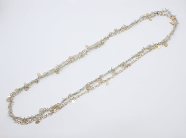 A long beige linen thread neckpiece with birch plywood tabs mirrors its sterling silver rope twist chain with silver and 10k yellow gold tabs. A sensuous material play, they can be worn singly. 42"/106 cm.
