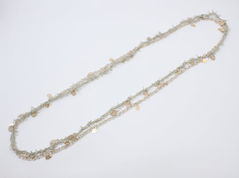 A long beige linen thread neckpiece with birch plywood tabs mirrors its sterling silver rope twist chain with silver and 10k yellow gold tabs. A sensuous material play, they can be worn singly. 42"/106 cm.