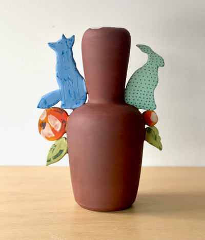 Tall ceramic vessel featuring a fox and rabbit, with colourful floral forms.