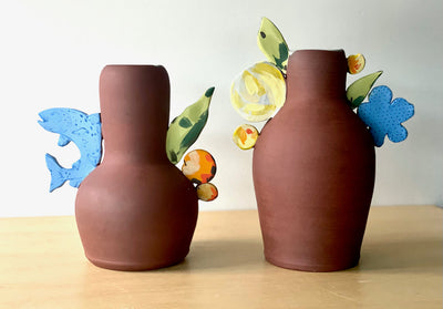 Tall ceramic vessel featuring a fish and colourful floral forms. (Pictured on the left)