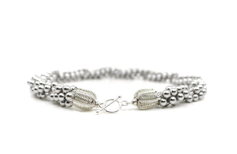 Eternal necklace, 2022. Swarovski pearls and clear crystals are braided into an elegant form using traditional Japanese kumihimo braiding. The clasp is made from woven sterling silver.