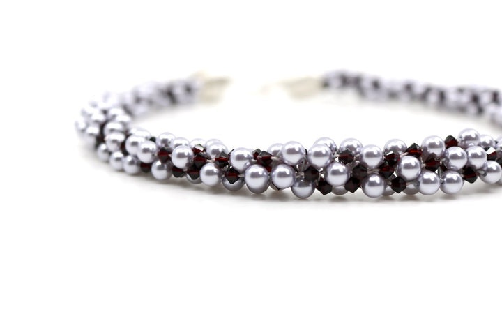 Royal necklace, 2022. Swarovski pearls and dark red crystals are braided into an elegant form using traditional Japanese kumihimo braiding. The clasp is made from woven sterling silver.