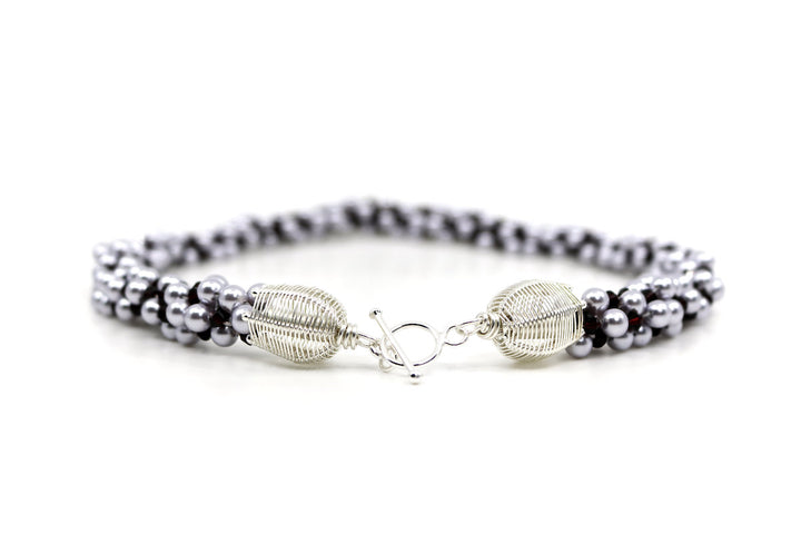 Royal necklace, 2022. Swarovski pearls and dark red crystals are braided into an elegant form using traditional Japanese kumihimo braiding. The clasp is made from woven sterling silver.